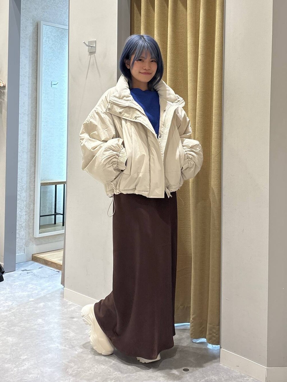 ホワイト系のその他アウター、ホワイト系のブーツ、ブラウン系のスカートを着用したレディースの冬コーディネートの5枚目の写真