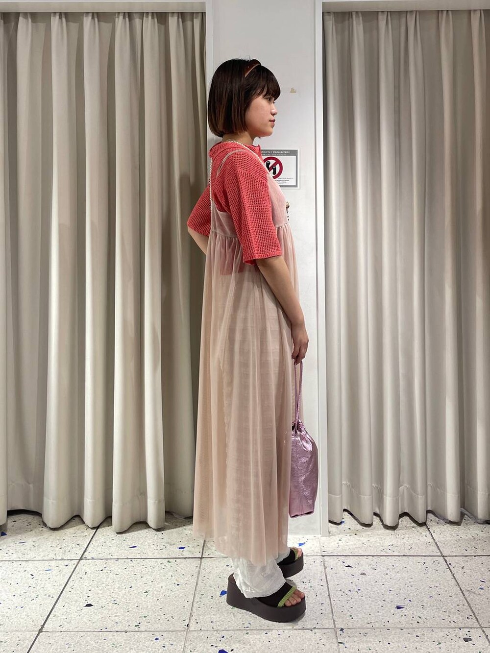 ピンク系のショルダーバッグ、ベージュ系のワンピース、ホワイト系のその他パンツを着用したレディースの春コーディネートの2枚目の写真