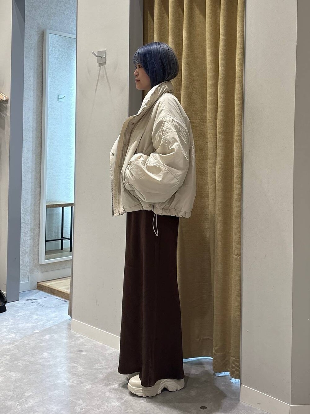 ホワイト系のその他アウター、ホワイト系のブーツ、ブラウン系のスカートを着用したレディースの冬コーディネートの2枚目の写真