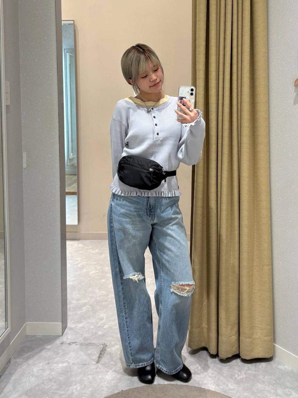 イエロー系のTシャツ/カットソー、ベージュ系のデニムパンツ、ホワイト系のブルゾンを着用したレディースの冬コーディネートの3枚目の写真