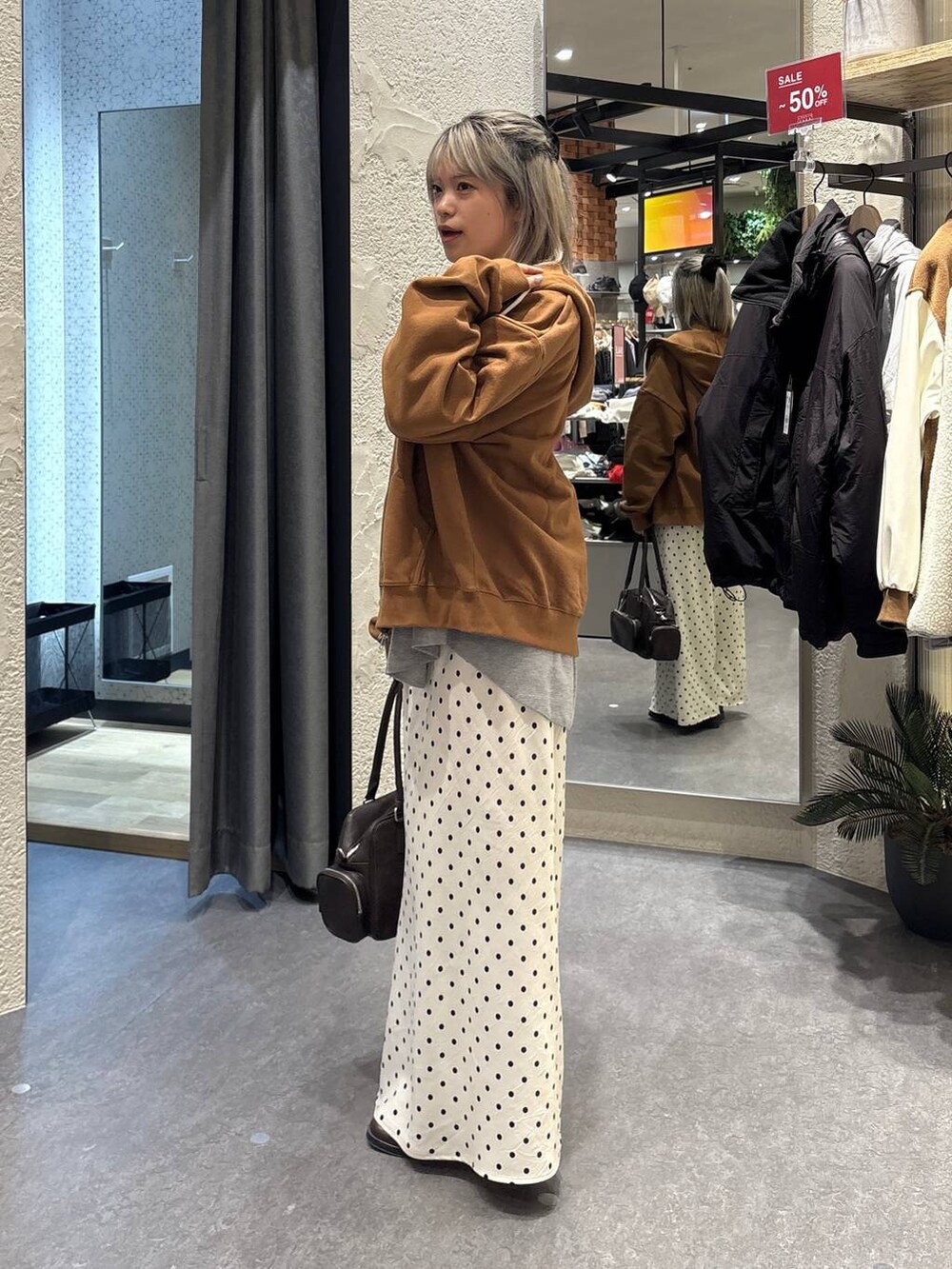 ホワイト系のスカート、ブラウン系のボストンバッグ、グレー系のTシャツ/カットソーを着用したレディースの冬コーディネートの2枚目の写真