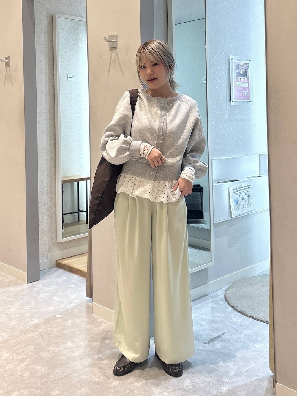 ブラウン系のトートバッグ、ブラウン系のローファー、グリーン系のその他パンツを着用したレディースの冬コーディネートの5枚目の写真