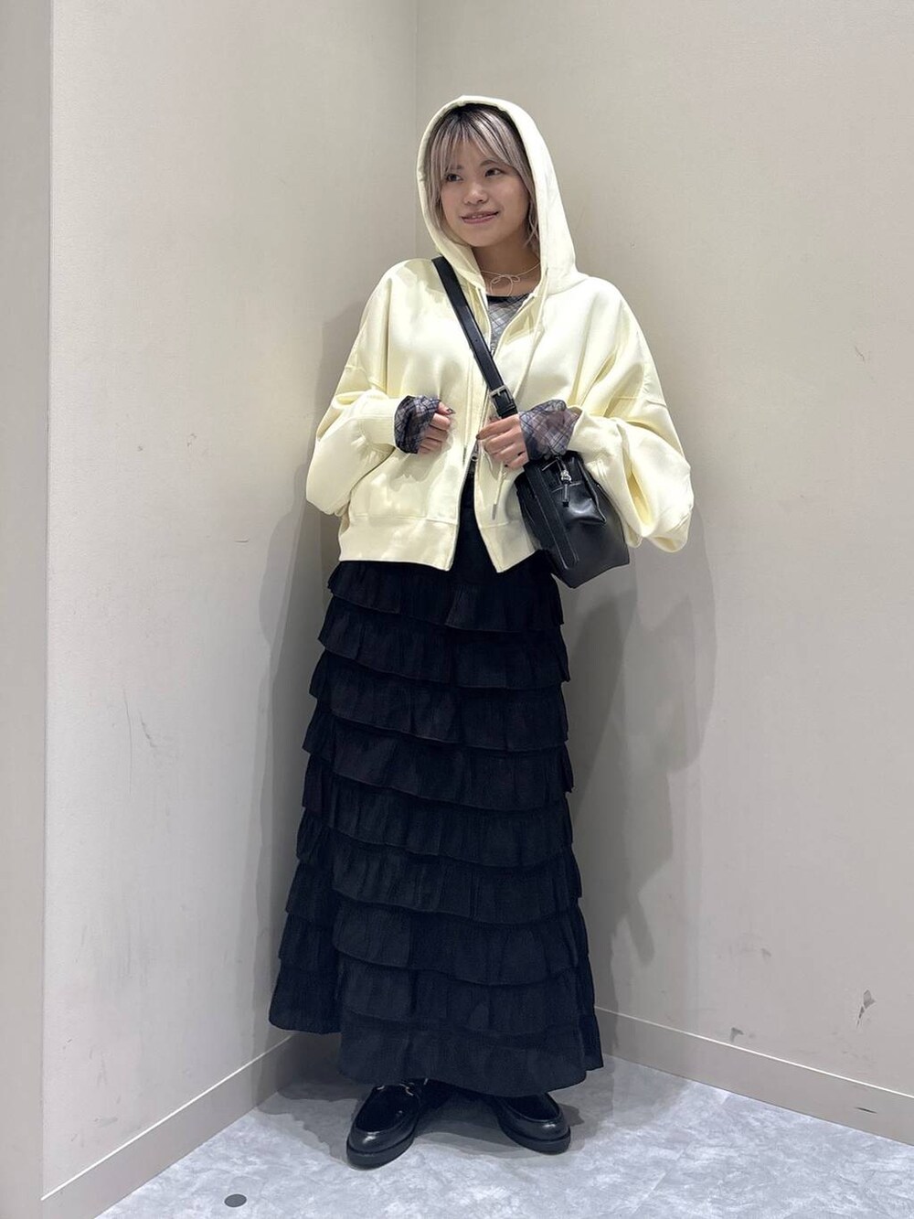 ブラック系のスカート、ブラック系のローファー、イエロー系のパーカーを着用したレディースの秋コーディネートの5枚目の写真