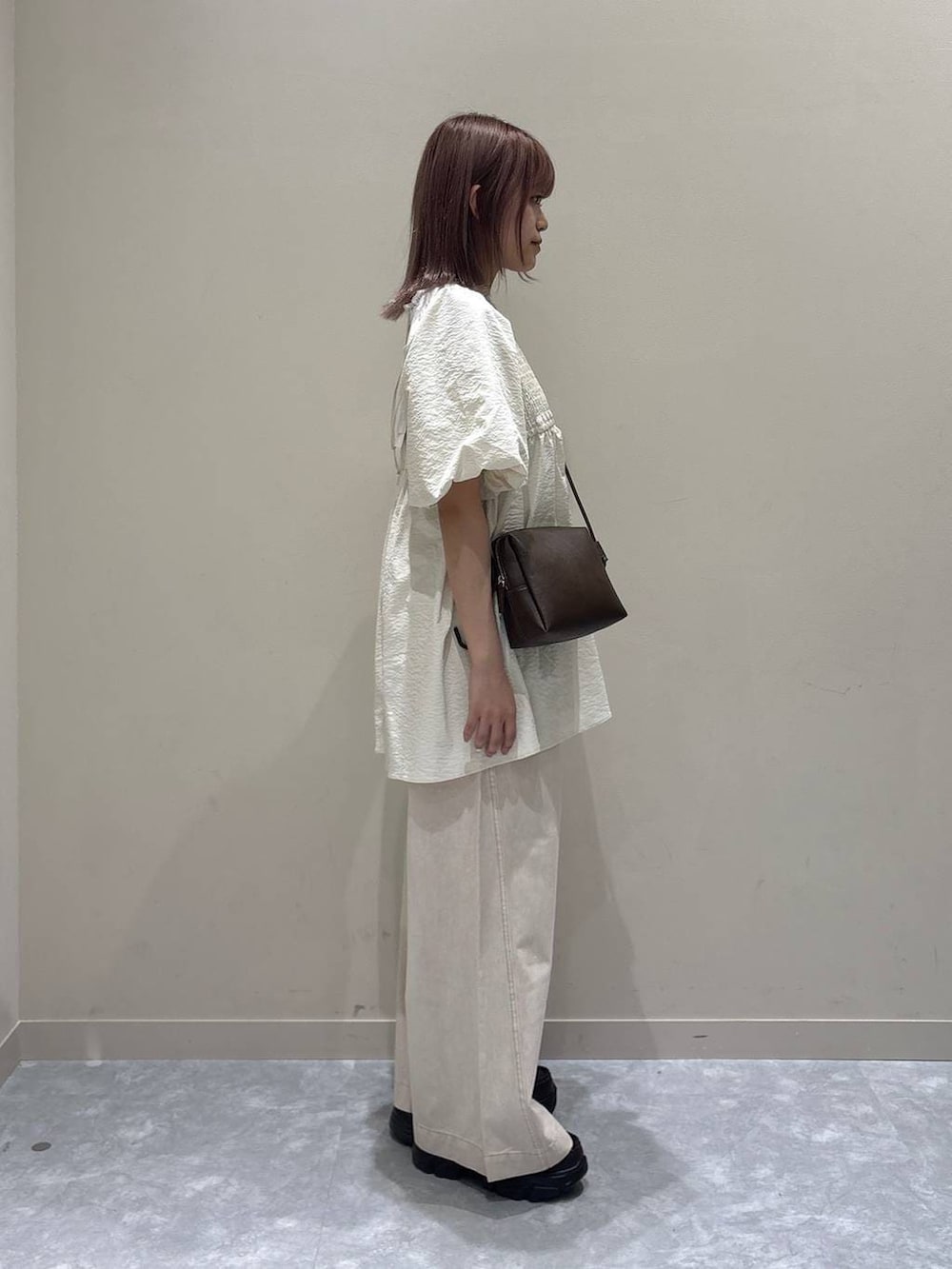 ピンク系のデニムパンツ、ブラウン系のローファー、ブラウン系のトートバッグを着用したレディースの春コーディネートの3枚目の写真