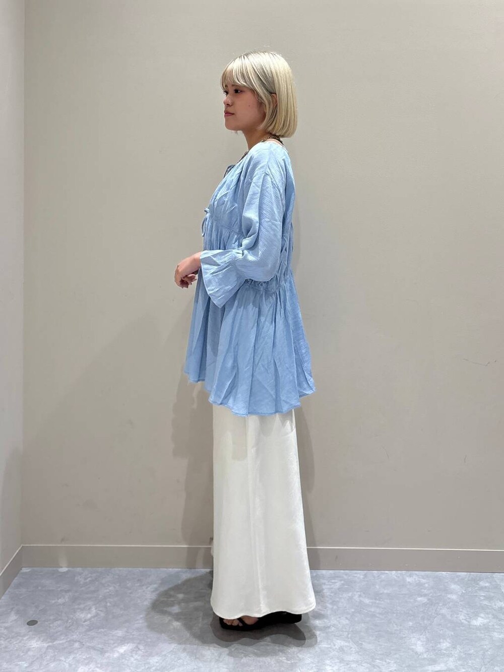 ブルー系のシャツ/ブラウス、ホワイト系のスカート、ブラウン系のサンダルを着用したレディースの夏コーディネートの2枚目の写真