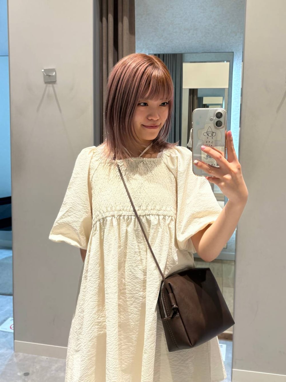 ピンク系のデニムパンツ、ブラウン系のローファー、ブラウン系のトートバッグを着用したレディースの春コーディネートの6枚目の写真