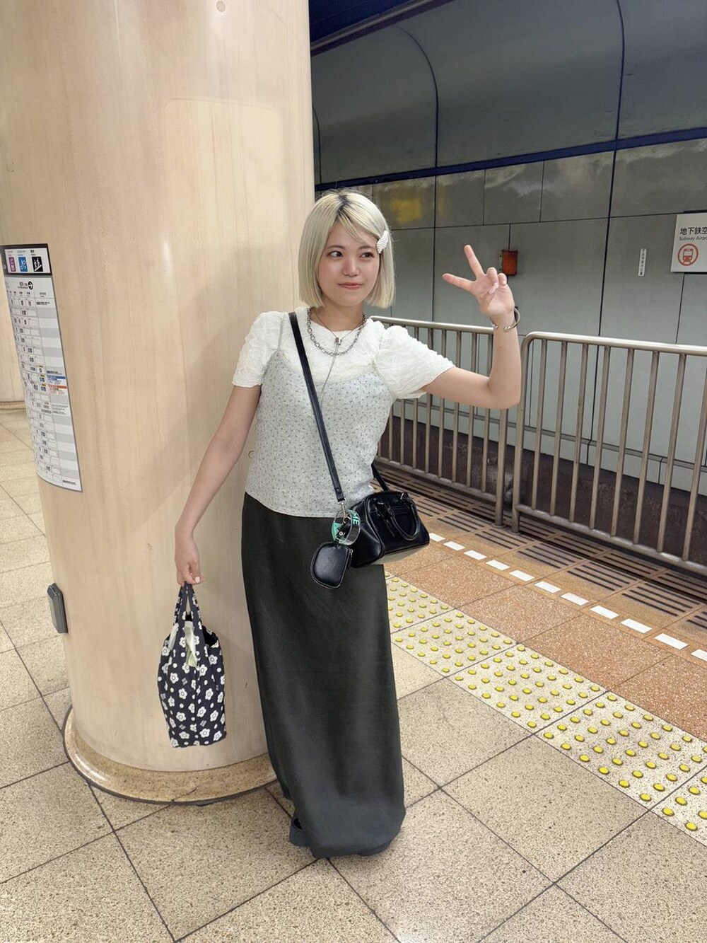 グレー系のキャミソール、ホワイト系のTシャツ/カットソー、ブラック系のショルダーバッグを着用したレディースの夏コーディネートの3枚目の写真