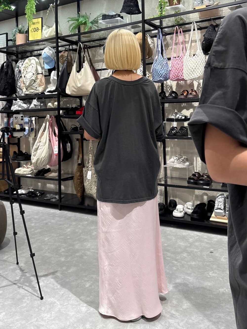 グレー系のスニーカー、ピンク系のスカート、ホワイト系のショルダーバッグを着用したレディースの夏コーディネートの3枚目の写真