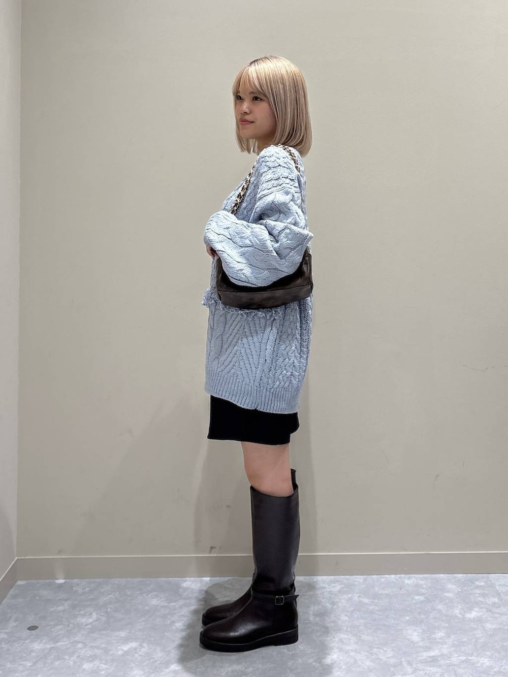 グレー系のその他パンツ、ブルー系のニット/セーター、ブラウン系のブーツを着用したレディースの冬コーディネートの2枚目の写真