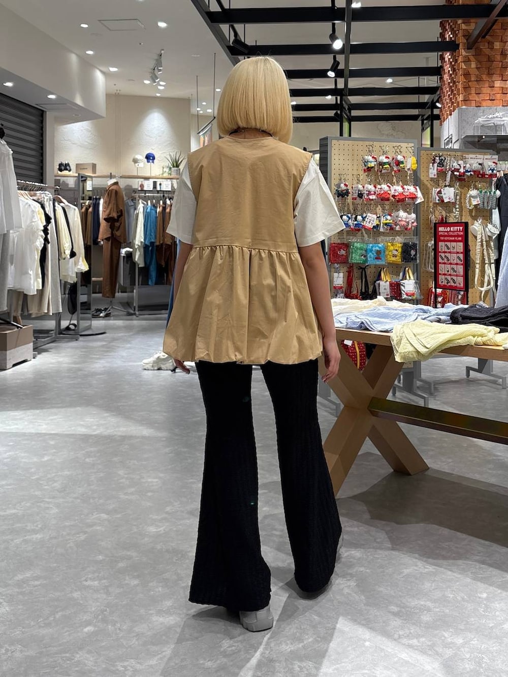 グレー系のスニーカー、ホワイト系のTシャツ/カットソー、ベージュ系のベストを着用したレディースの春コーディネートの3枚目の写真