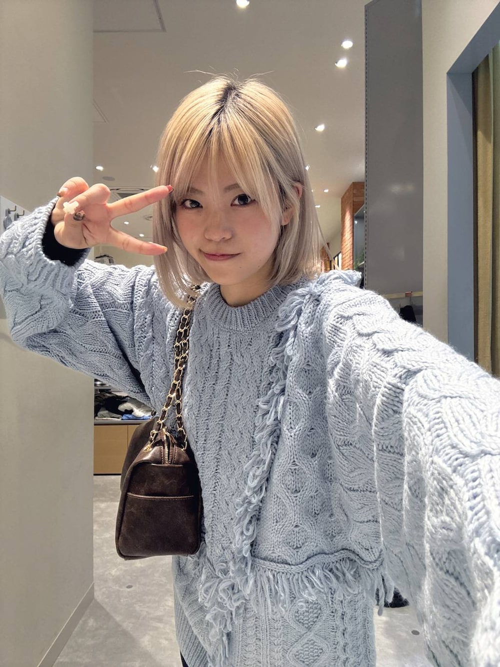 グレー系のその他パンツ、ブルー系のニット/セーター、ブラウン系のブーツを着用したレディースの冬コーディネートの5枚目の写真