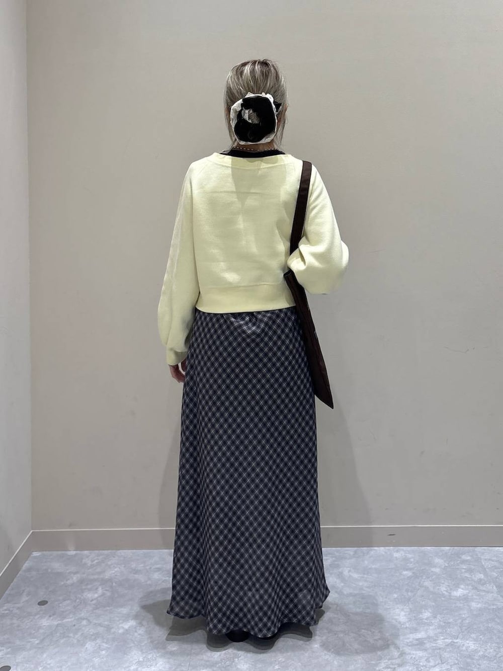 ブラウン系のトートバッグ、ブラック系のローファー、イエロー系のスウェットを着用したレディースの冬コーディネートの3枚目の写真