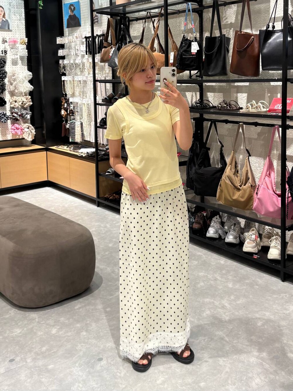 イエロー系のTシャツ/カットソー、ブラウン系のサンダル、ホワイト系のスカートを着用したレディースの夏コーディネートの4枚目の写真