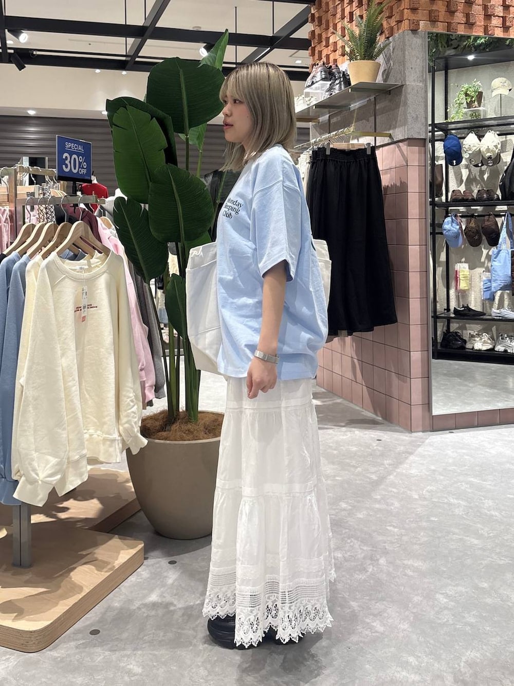 ブラック系のローファー、ブルー系のTシャツ/カットソー、ホワイト系のスカートを着用したレディースの春コーディネートの4枚目の写真