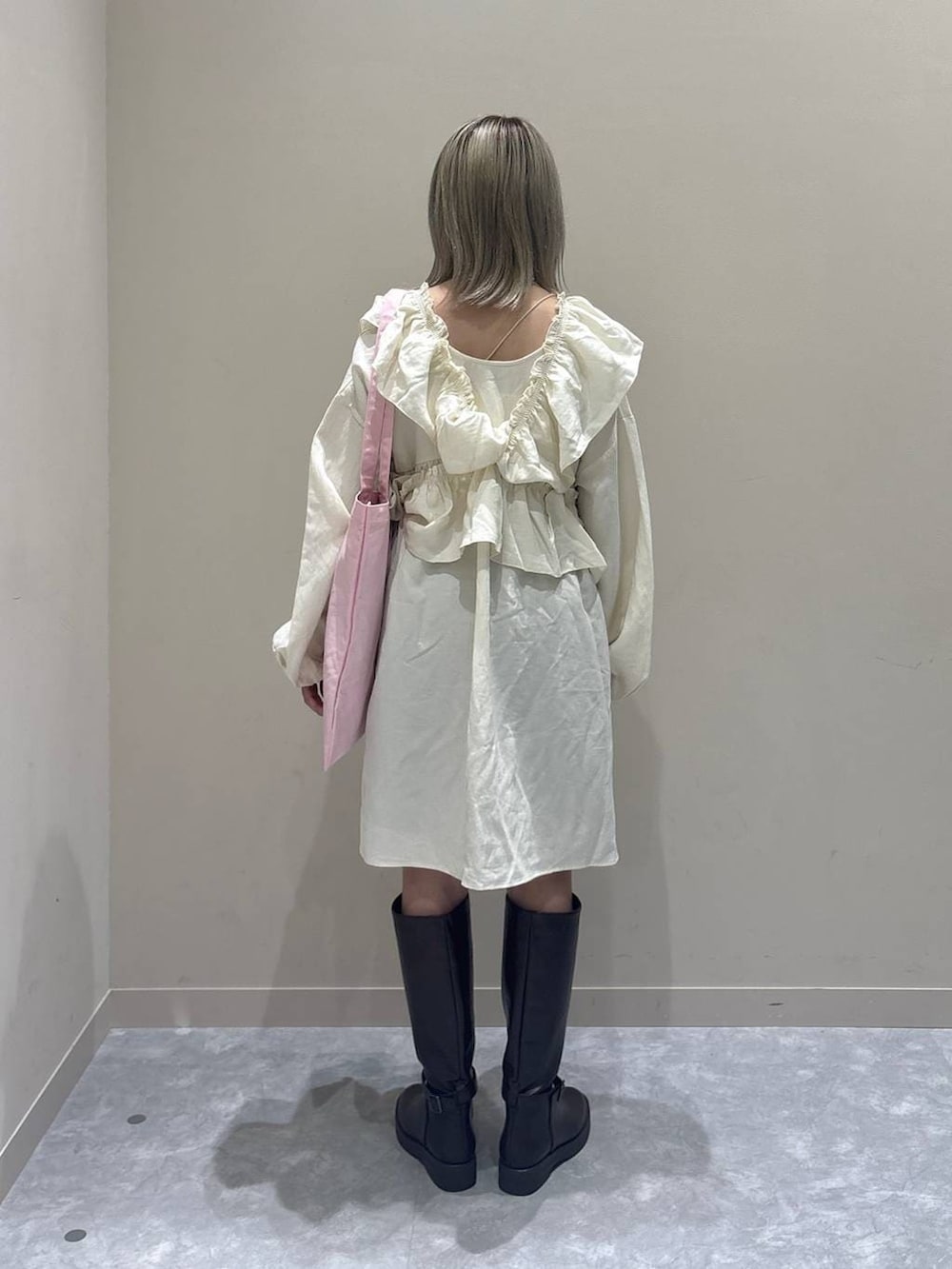 ブラック系のその他パンツ、ブラウン系のブーツ、ピンク系のトートバッグを着用したレディースの冬コーディネートの3枚目の写真