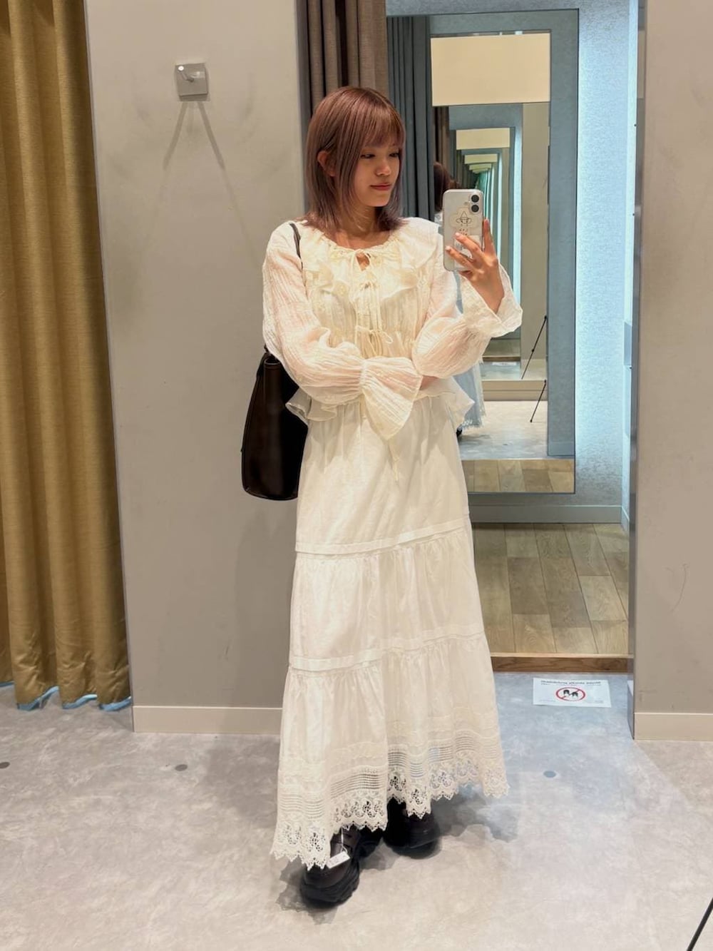 ブラウン系のローファー、ブラウン系のトートバッグ、ホワイト系のスカートを着用したレディースの春コーディネートの2枚目の写真