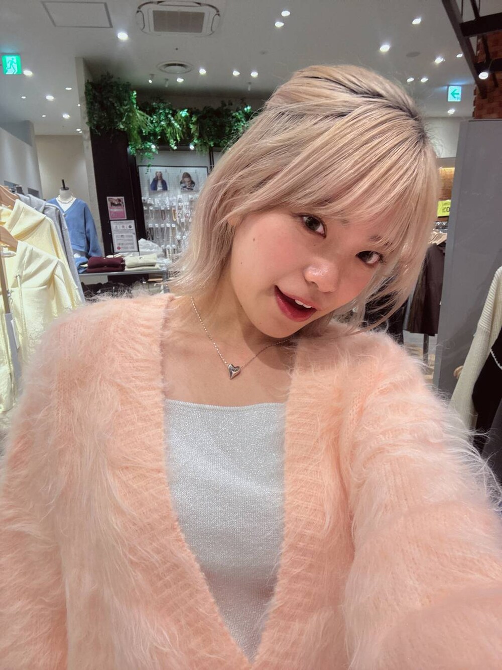 シルバー系のタンクトップ、ピンク系のカーディガン/ボレロ、シルバー系のネックレスを着用したレディースの秋コーディネートの2枚目の写真