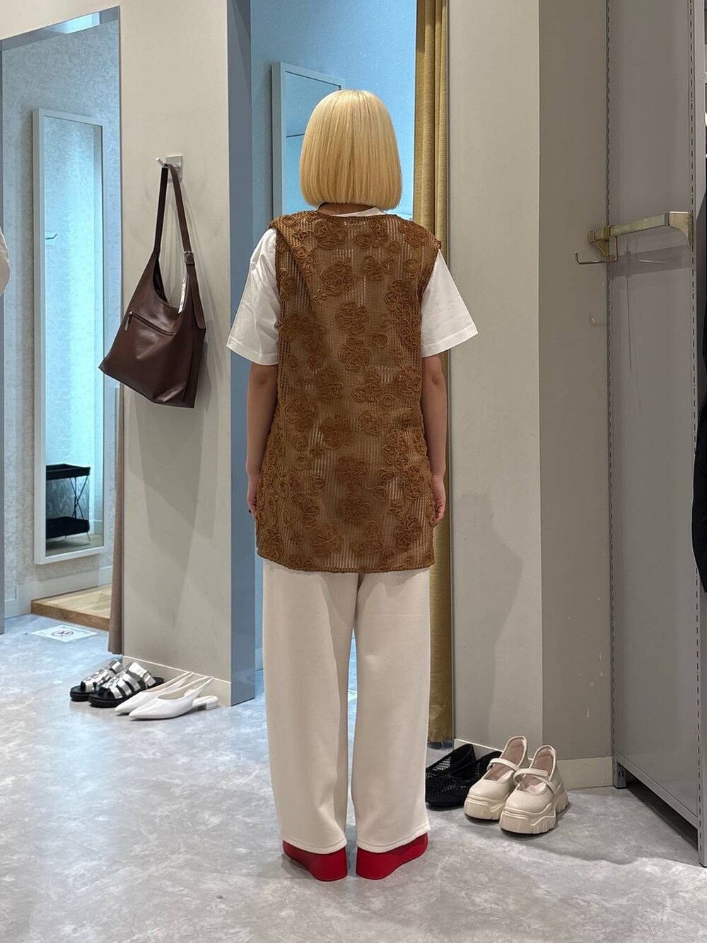 レッド系のサンダル、ホワイト系のTシャツ/カットソー、ブラウン系のベストを着用したレディースの春コーディネートの3枚目の写真