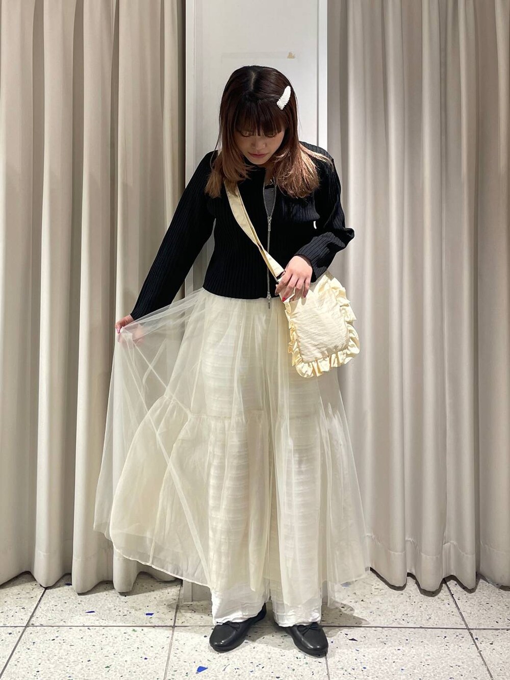 ホワイト系のその他パンツ、ブラック系のカーディガン/ボレロ、ホワイト系のスカートを着用したレディースの春コーディネートの5枚目の写真