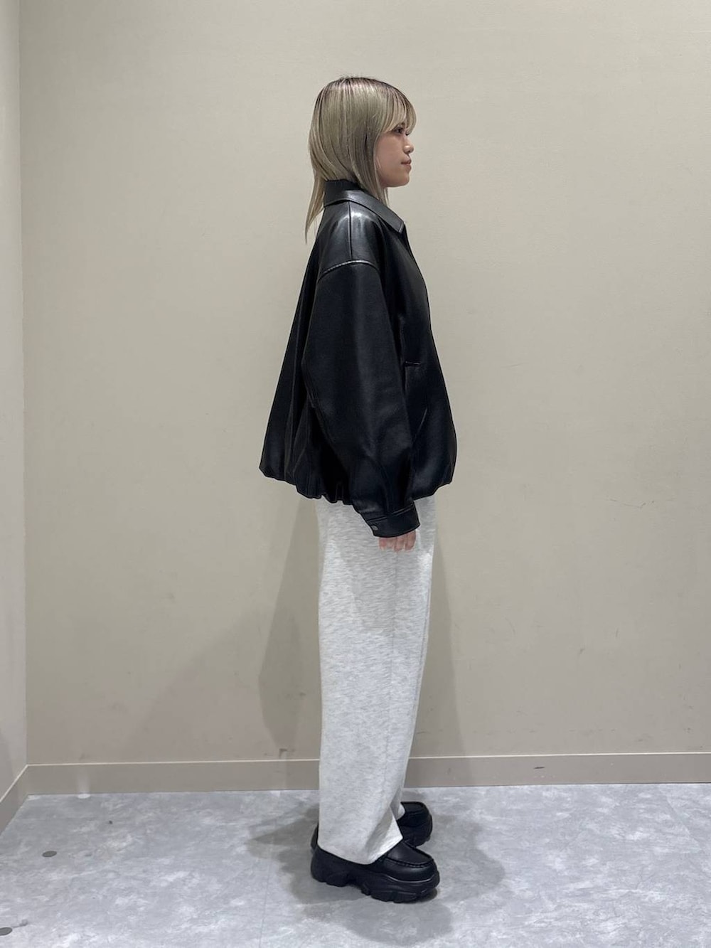 グレー系のスウェットパンツ、ホワイト系のブルゾン、ブラック系のローファーを着用したレディースの春コーディネートの4枚目の写真