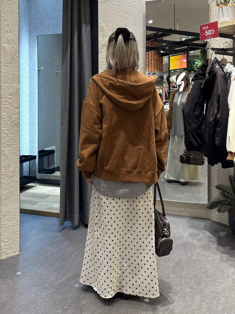 ホワイト系のスカート、ブラウン系のボストンバッグ、グレー系のTシャツ/カットソーを着用したレディースの冬コーディネートの3枚目の写真