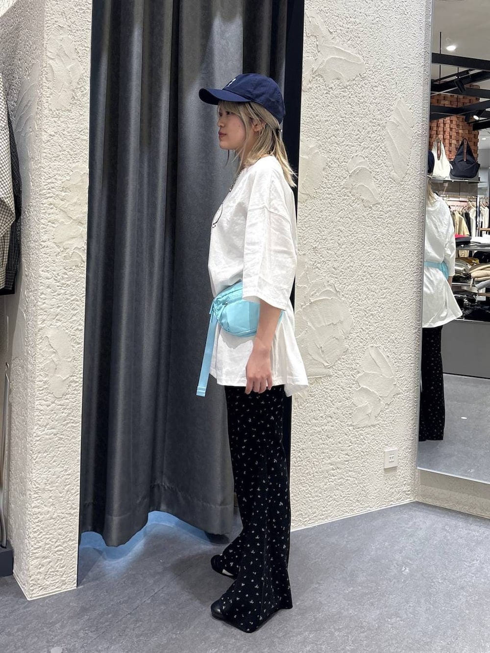 ブルー系のボディバッグ/ウエストポーチ、ブラック系のその他パンツ、ホワイト系のTシャツ/カットソーを着用したレディースの春コーディネートの2枚目の写真