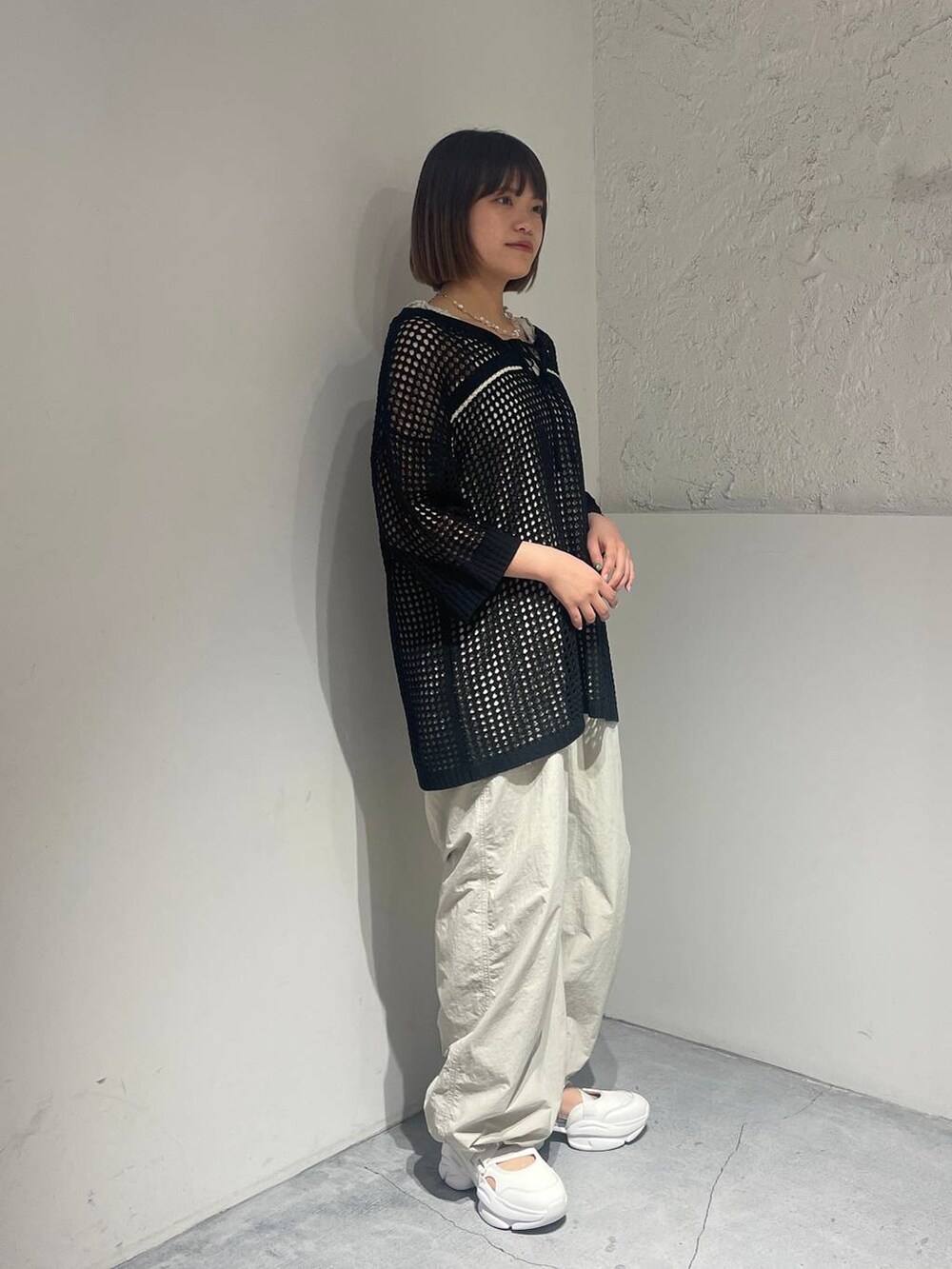 ホワイト系のサンダル、ホワイト系のサロペット/オーバーオール、ブラック系のニット/セーターを着用したレディースの春コーディネートの2枚目の写真