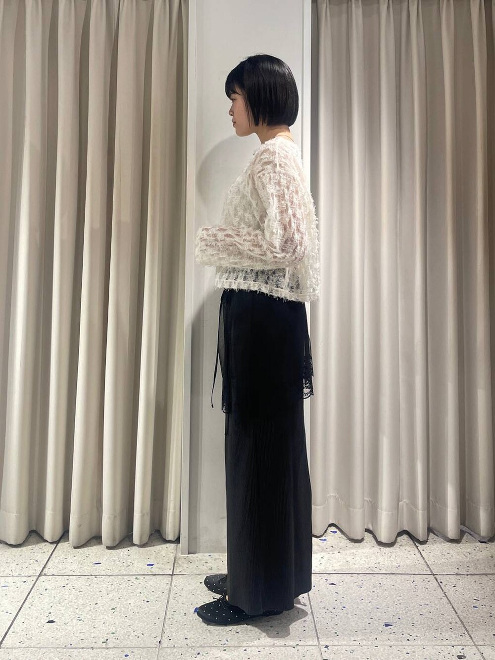 ブラック系のスカート、ブラック系のバレエシューズ、ブラック系のショルダーバッグを着用したレディースの秋コーディネートの4枚目の写真