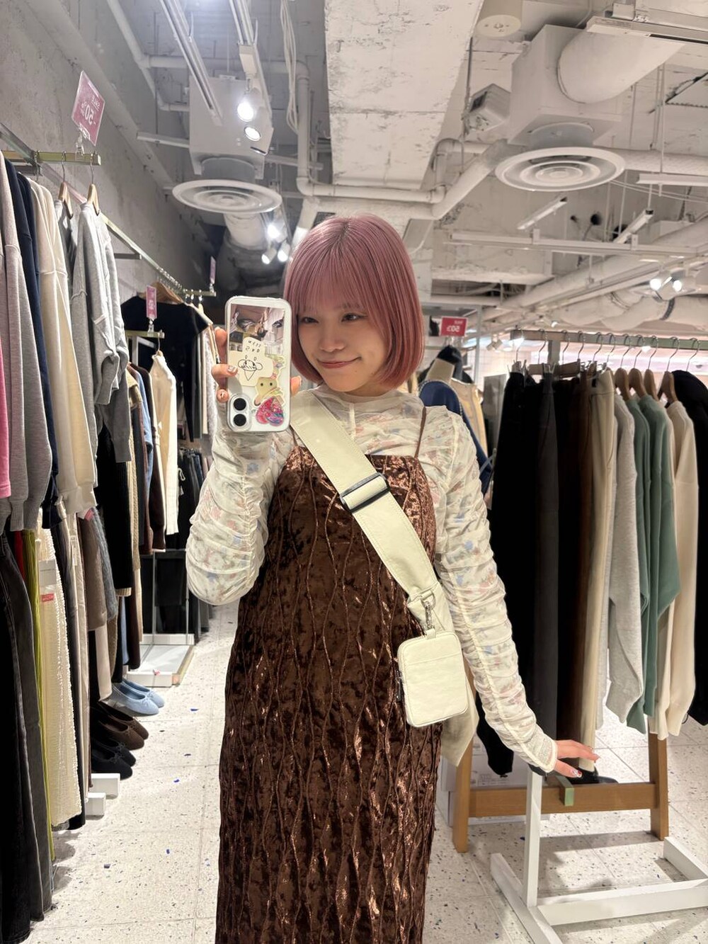 ブラウン系のワンピース、ホワイト系のTシャツ/カットソー、ベージュ系のショルダーバッグを着用したレディースの冬コーディネートの2枚目の写真