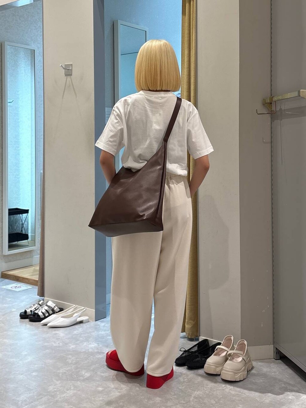 ブラウン系のショルダーバッグ、レッド系のサンダル、ホワイト系のTシャツ/カットソーを着用したレディースの春コーディネートの3枚目の写真