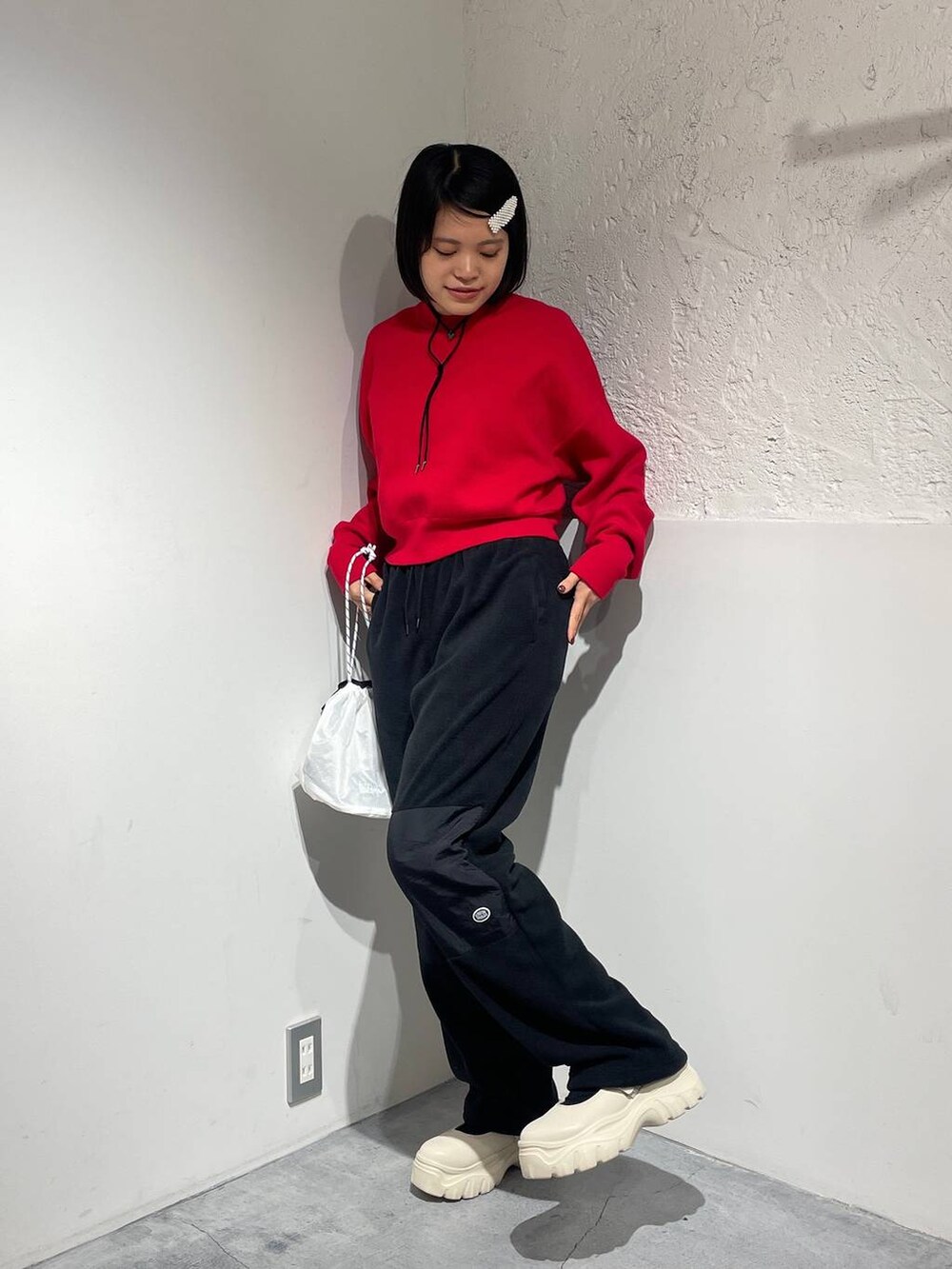 ブラック系のその他パンツ、ホワイト系のスニーカー、レッド系のニット/セーターを着用したレディースの秋コーディネートの4枚目の写真