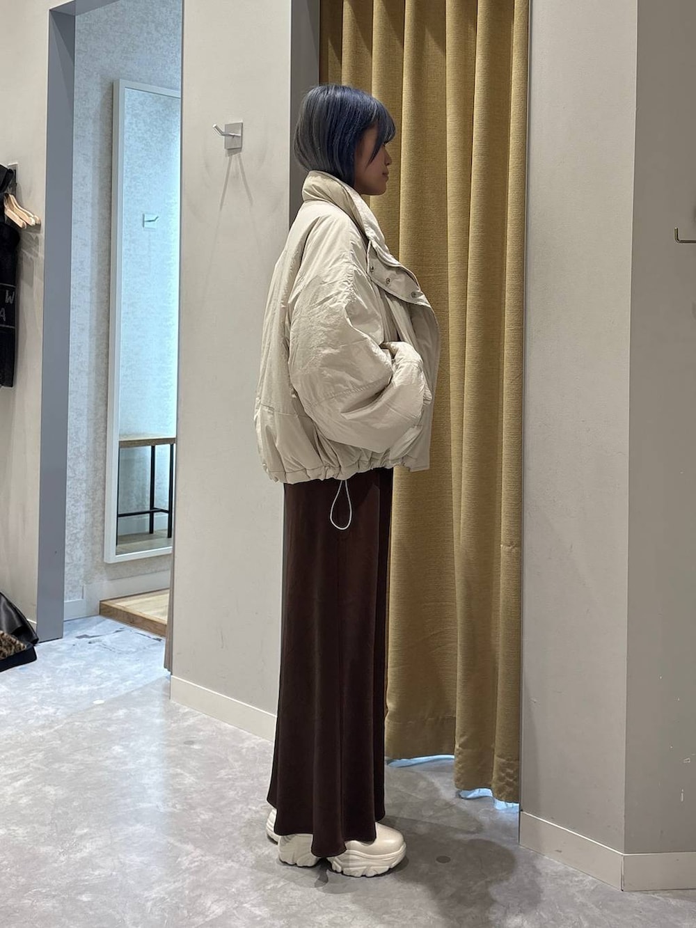 ホワイト系のその他アウター、ホワイト系のブーツ、ブラウン系のスカートを着用したレディースの冬コーディネートの4枚目の写真