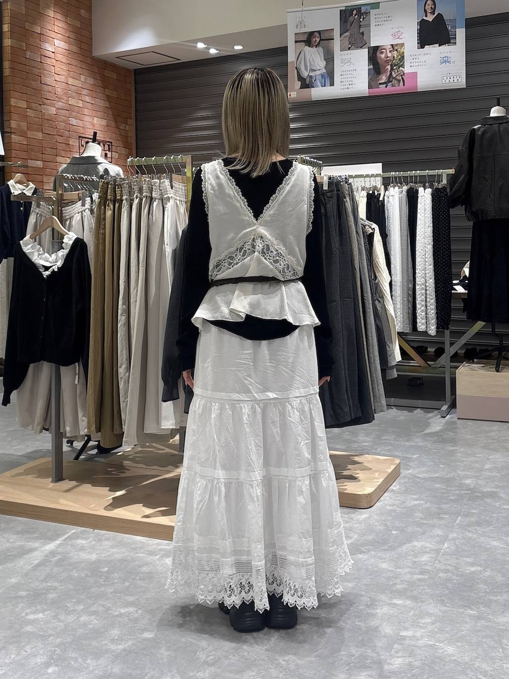 ブラック系のニット/セーター、ブラック系のローファー、ホワイト系のベストを着用したレディースの春コーディネートの3枚目の写真