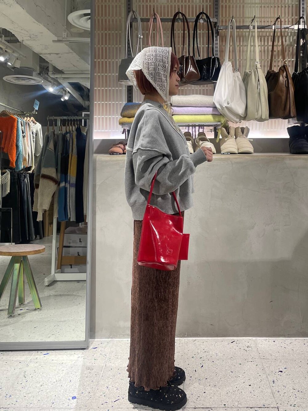 ブラウン系のスカート、グレー系のスウェット、その他のブーツを着用したレディースの冬コーディネートの2枚目の写真