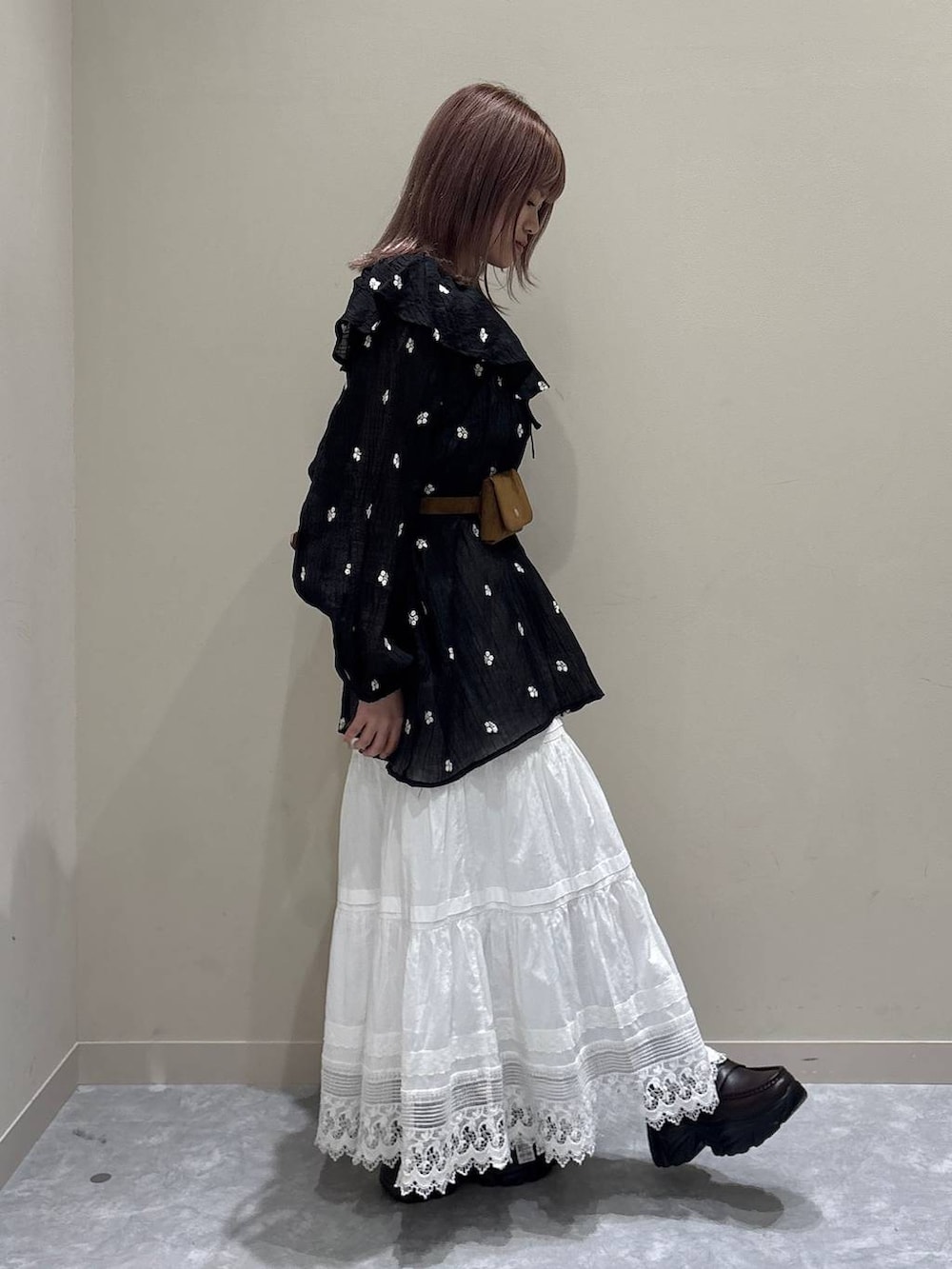 ブラウン系のローファー、ホワイト系のスカート、ブラック系のワンピースを着用したレディースの春コーディネートの4枚目の写真