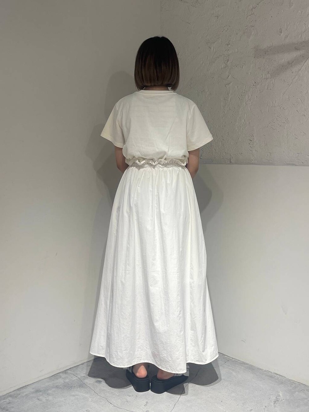 シルバー系のサンダル、ホワイト系のワンピース、シルバー系のネックレスを着用したレディースの春コーディネートの3枚目の写真