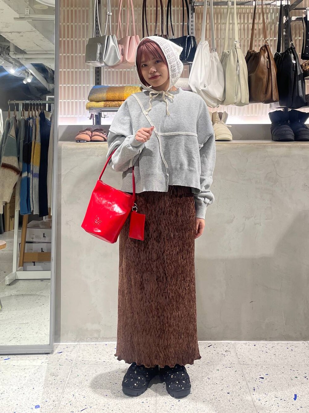 ブラウン系のスカート、グレー系のスウェット、その他のブーツを着用したレディースの冬コーディネートの5枚目の写真