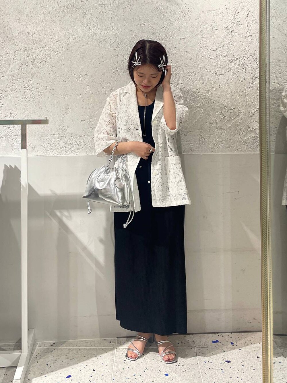 ブラック系のスカート、シルバー系のサンダル、ホワイト系のシャツ/ブラウスを着用したレディースの春コーディネートの5枚目の写真