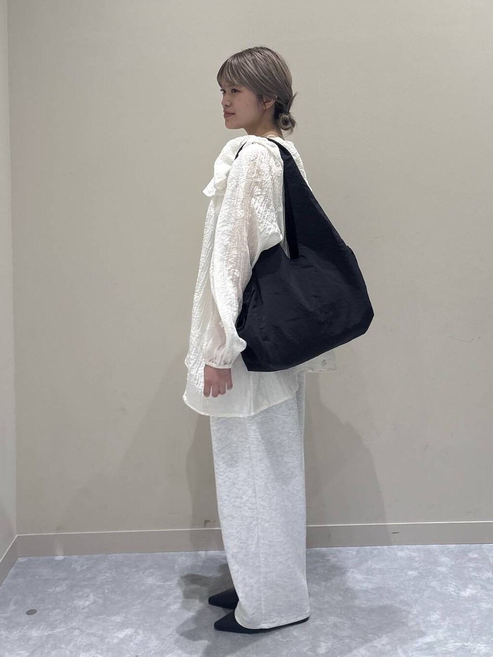 グレー系のスウェットパンツ、ブラック系のサンダル、ブラック系のトートバッグを着用したレディースの春コーディネートの2枚目の写真