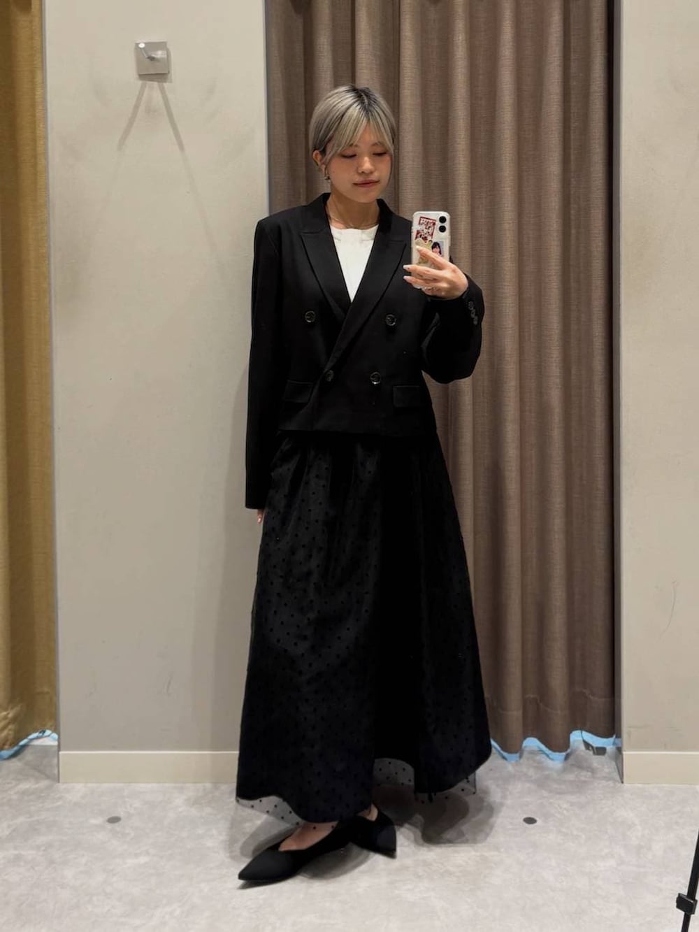 ブラック系のテーラードジャケット、ホワイト系のシャツ/ブラウス、ブラック系のスカートを着用したレディースの冬コーディネートの2枚目の写真