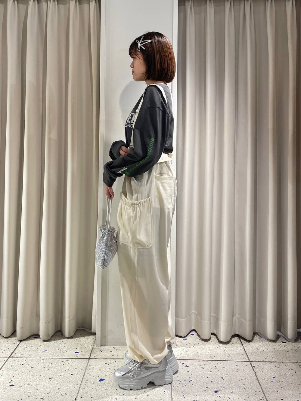 ホワイト系のワンピース、シルバー系のスニーカー、シルバー系のショルダーバッグを着用したレディースの秋コーディネートの2枚目の写真