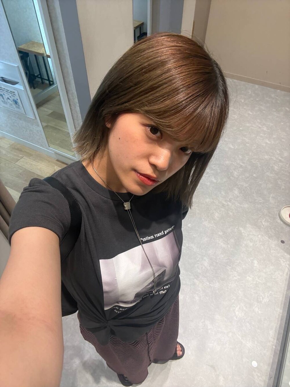 グレー系のTシャツ/カットソー、ブラック系のショルダーバッグ、ブラウン系のサンダルを着用したレディースの夏コーディネートの3枚目の写真