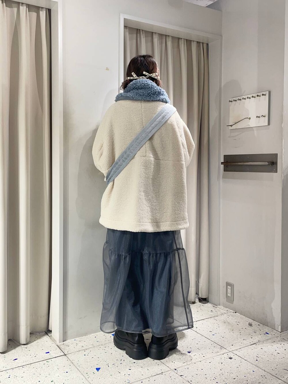 ホワイト系のTシャツ/カットソー、ブラック系のブーツ、ホワイト系のブルゾンを着用したレディースの冬コーディネートの3枚目の写真