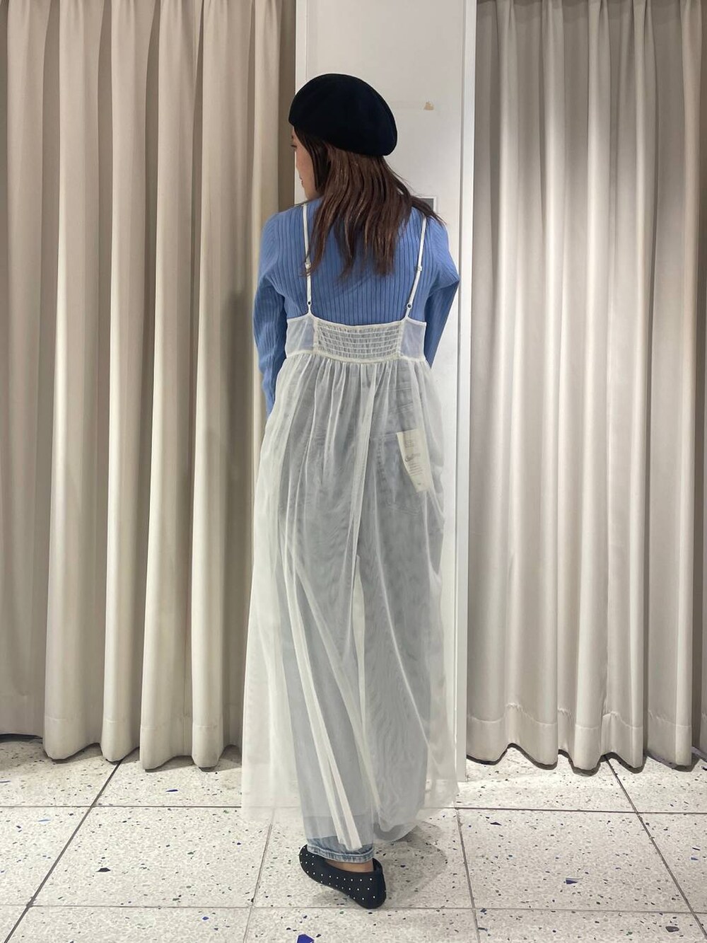 ホワイト系のワンピース、ブルー系のデニムパンツ、ブルー系のニット/セーターを着用したレディースの冬コーディネートの3枚目の写真