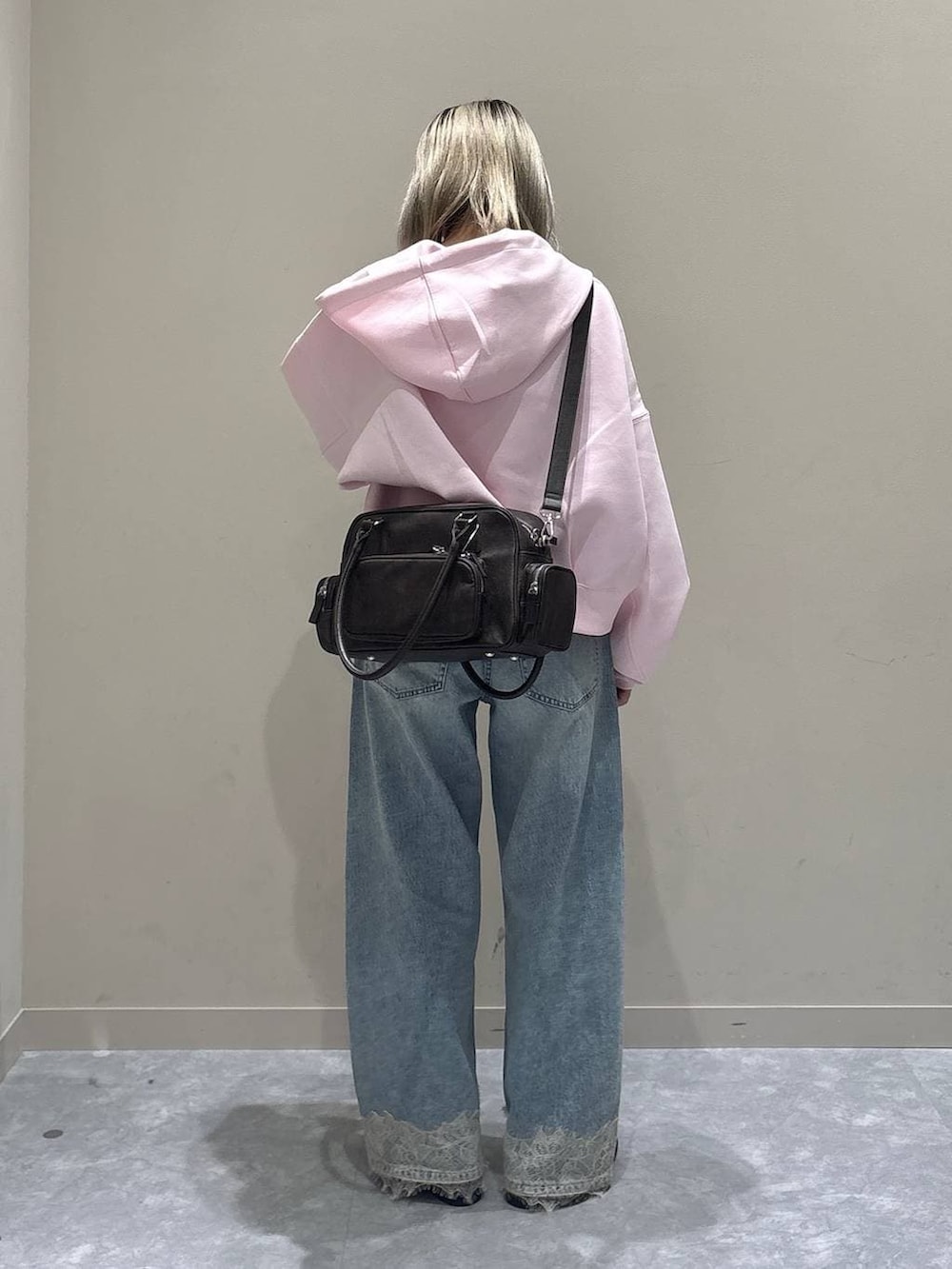 ピンク系のパーカー、ブルー系のデニムパンツ、ブラウン系のローファーを着用したレディースの春コーディネートの3枚目の写真