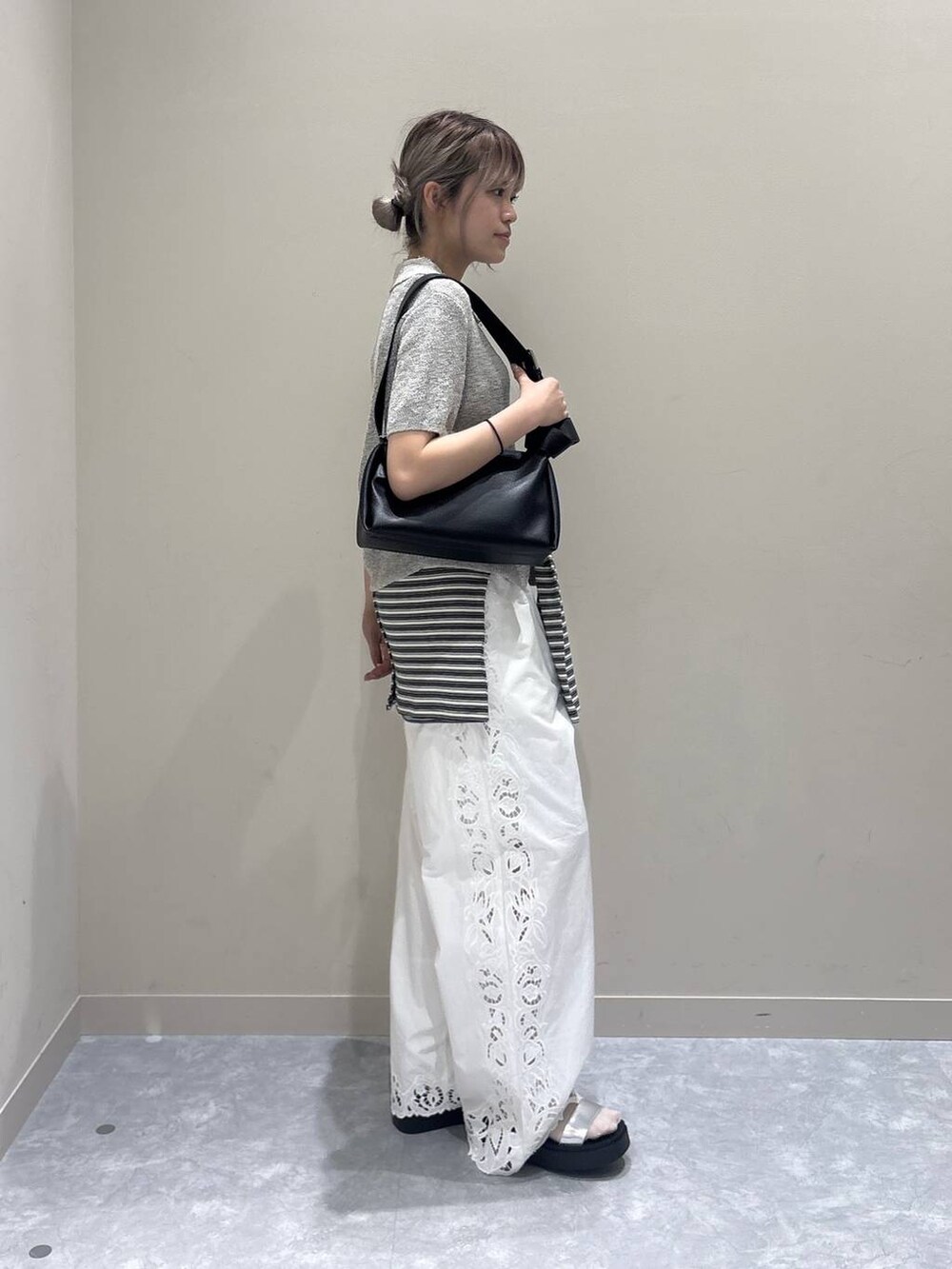 シルバー系のサンダル、ブラック系のショルダーバッグ、ホワイト系のその他パンツを着用したレディースの春コーディネートの2枚目の写真