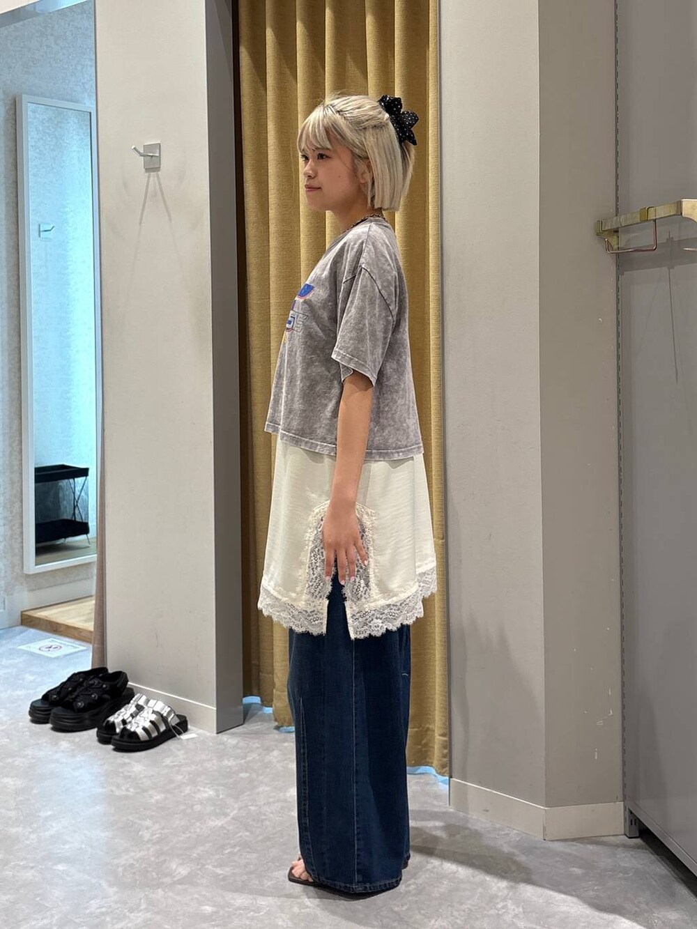 ブルー系のデニムパンツ、ブラウン系のサンダル、グレー系のTシャツ/カットソーを着用したレディースの夏コーディネートの2枚目の写真
