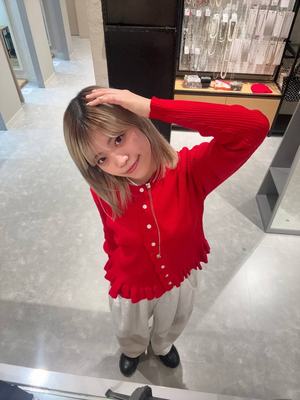 グレー系のスウェットパンツ、ブラック系のローファー、レッド系のTシャツ/カットソーを着用したレディースの春コーディネートの2枚目の写真