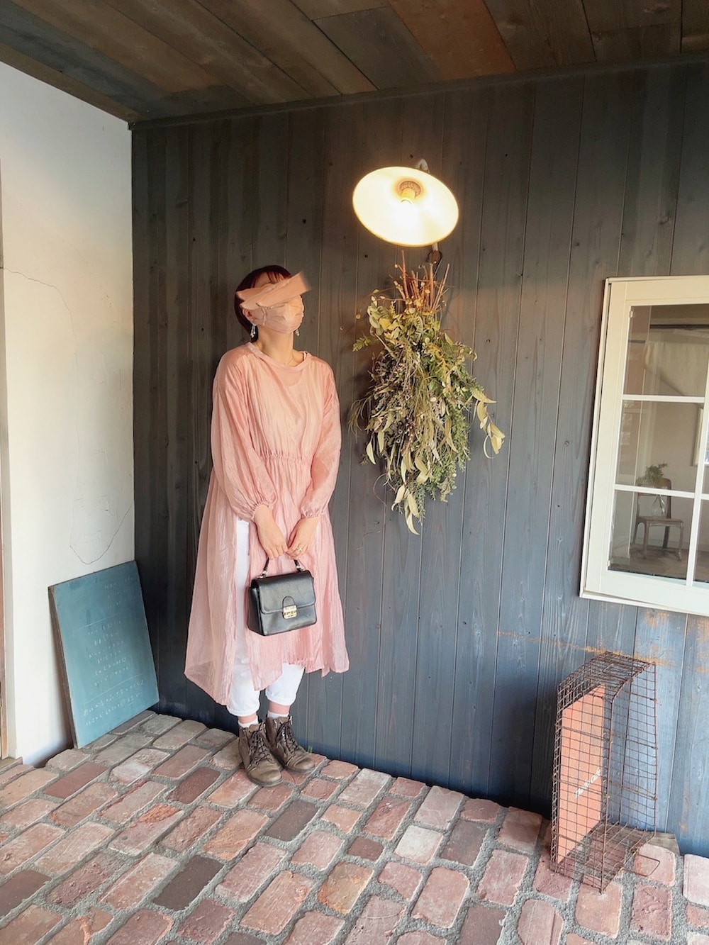 ブラック系のバッグ、ベージュ系のトレンチコート、ピンク系のワンピースを着用したレディースの春コーディネートの2枚目の写真