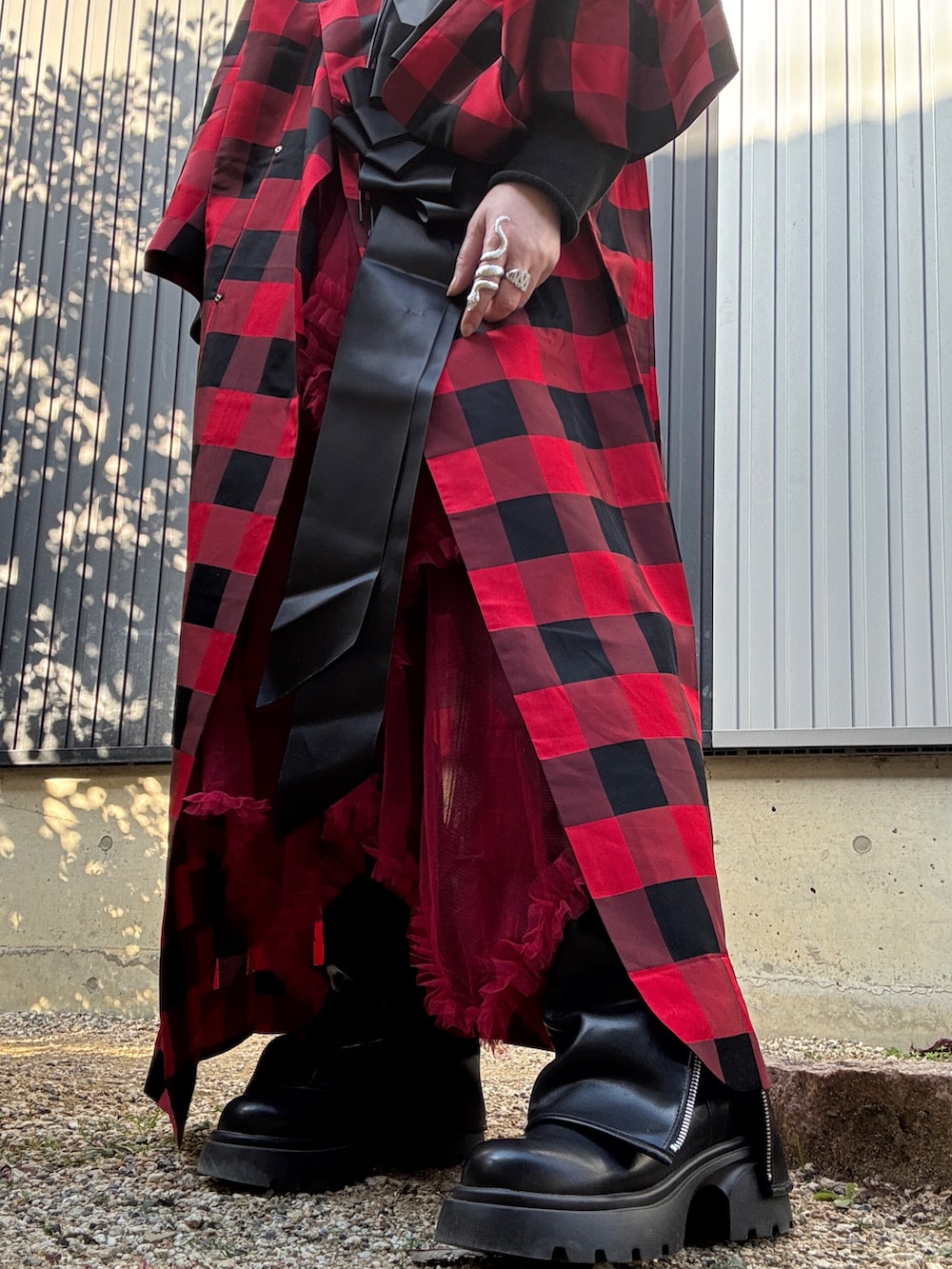 レッド系のスカート、ブラック系のシューズ、ブラック系のファッション雑貨を着用したレディースの冬コーディネートの3枚目の写真